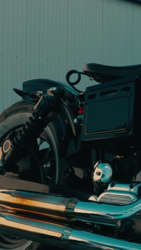 Detail einer Custom Harley-Davidson in dunklem Petrol und Chrom